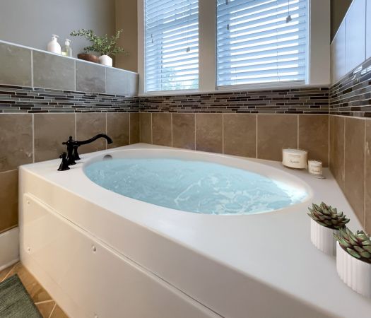 The Village at Commonwealth apartment large soaking tub with decorative tile walls