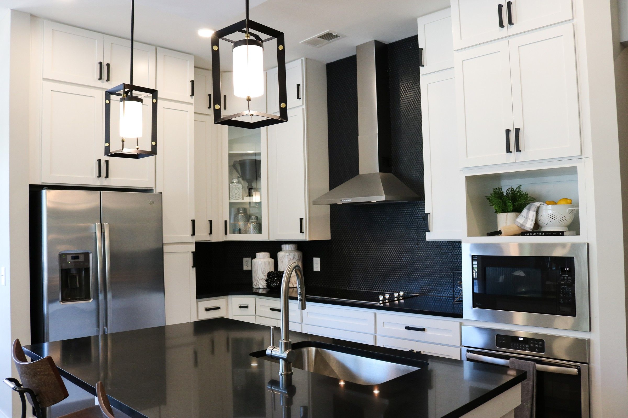 The Village at Commonwealth modern kitchen with high ceilings, custom cabinetry, penny tile backsplash, and stainless steel appliances