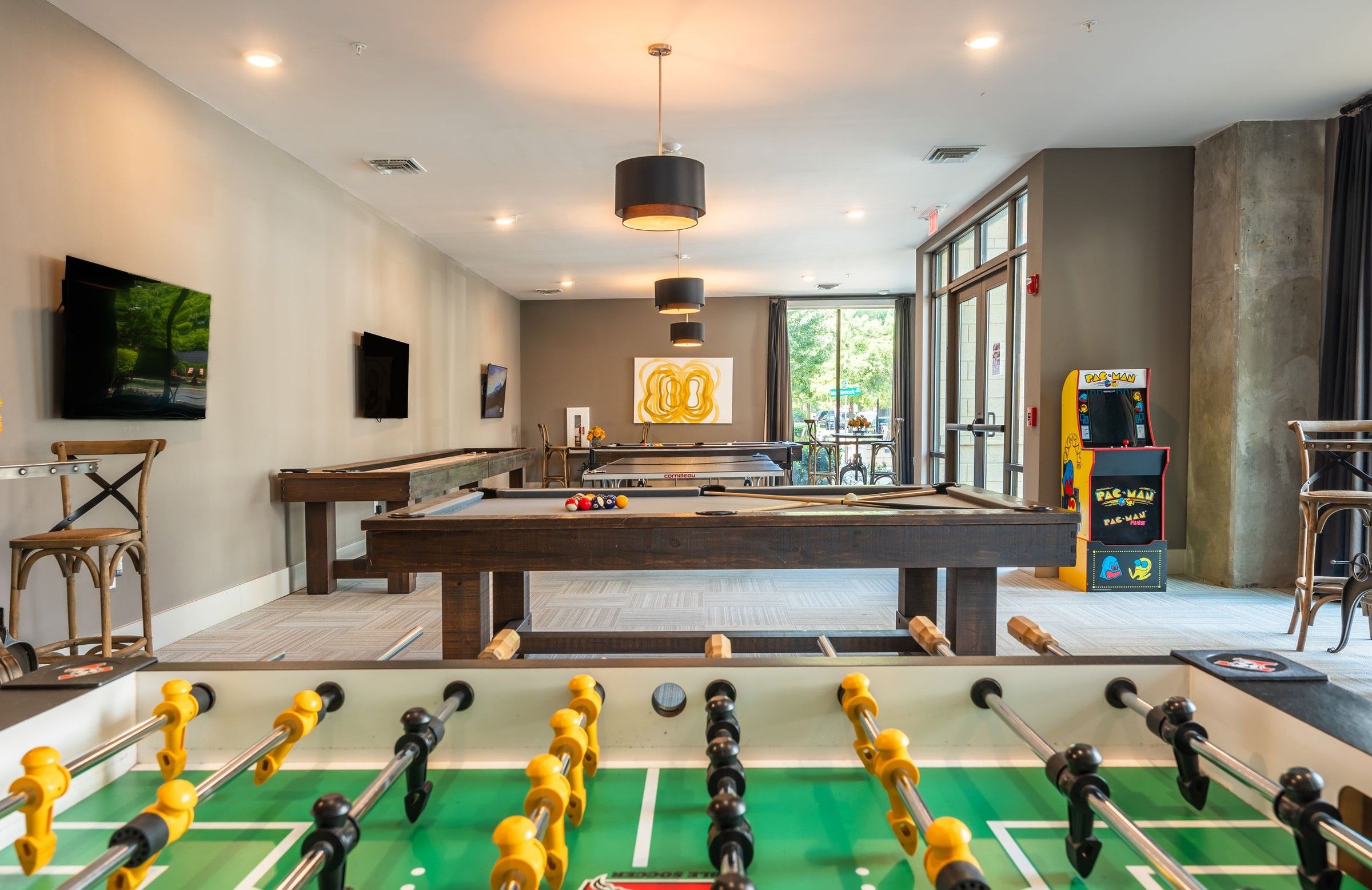 The Village at Commonwealth large game room with foosball, billards, shuffleboard, Pacman, and more.