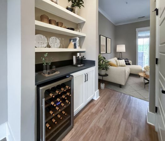 The Village at Commonwealth apartment hallway with floating shelves, countertop, and wine fridge