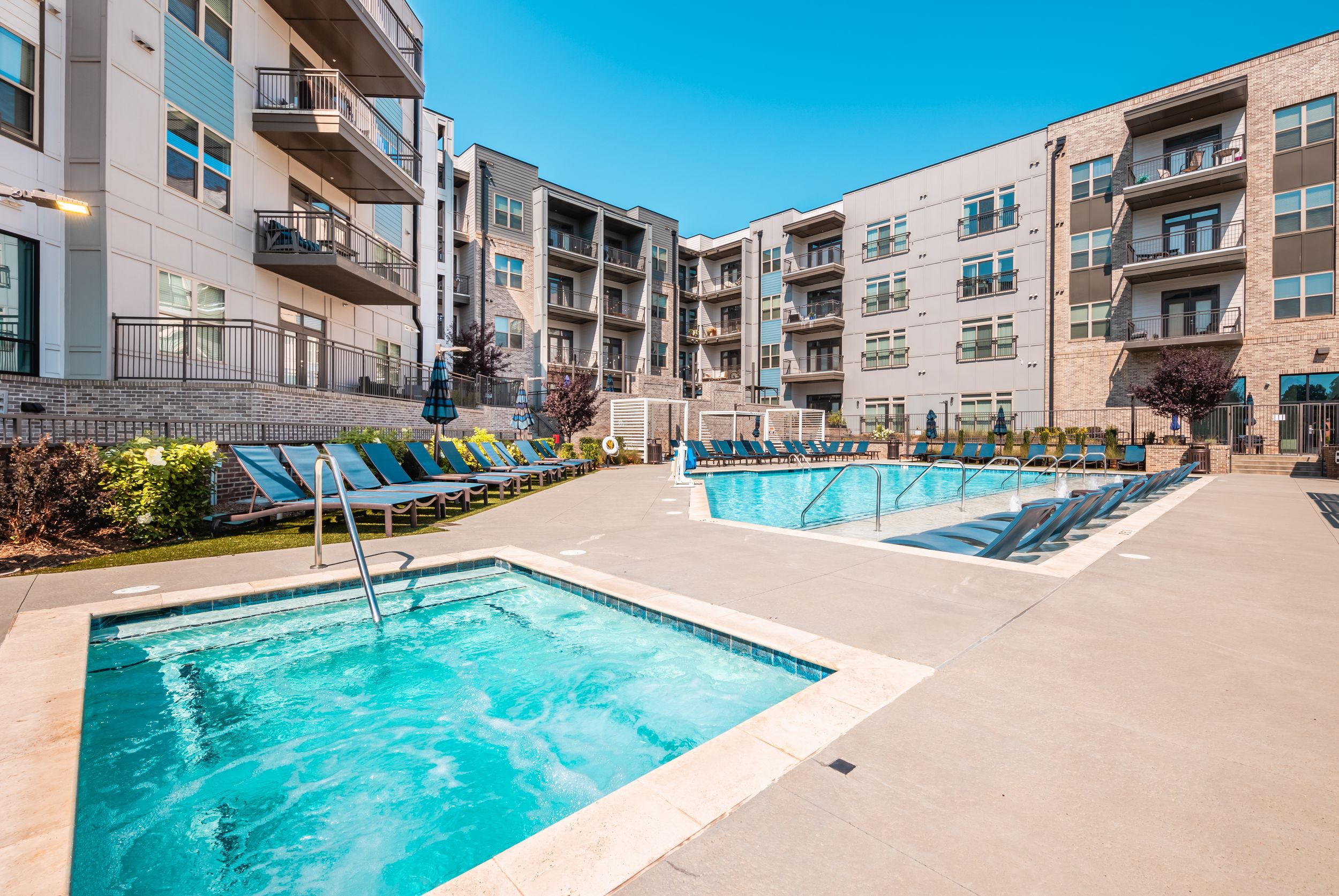 The Village at Commonwealth resort-style luxury outdoor pool and spa with surrounding lounge seating