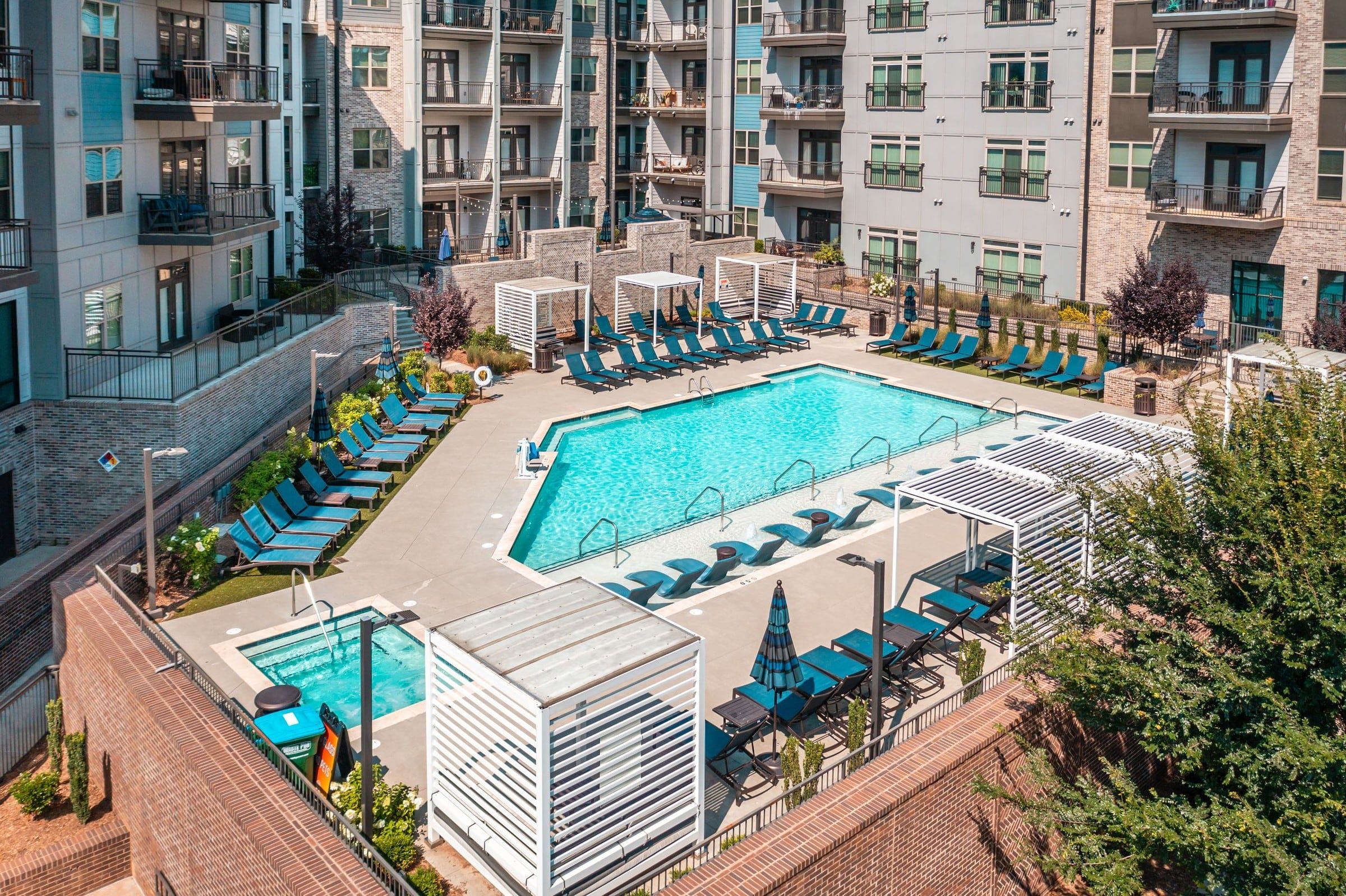 The Village at Commonwealth outdoor salt water swimming pool with in-pool lounge seats and outdoor jacuzzi