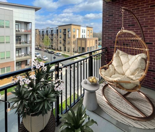 The Village at Commonwealth 3-bedroom large apartment balcony with trendy chair and tropical plants