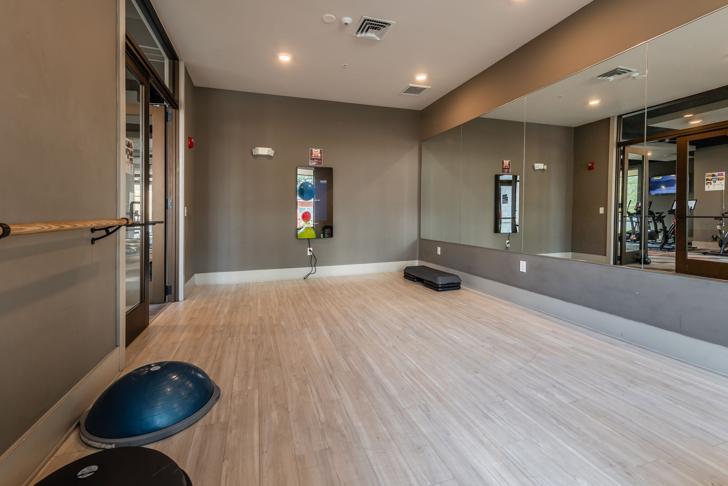 The Village at Commonwealth fitness center with climbing ropes, benches, squat racks, and more