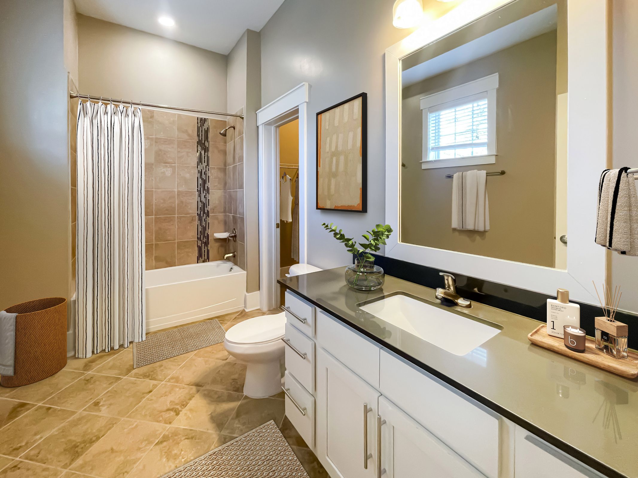 The Village at Commonwealth apartment large bathroom with shower, toilet, and large vanity and sink